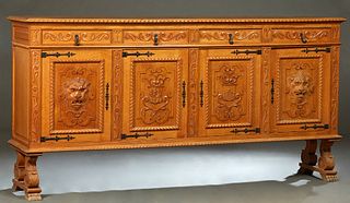 French Renaissance Style Carved Oak Sideboard, 20th c., the parquetry inlaid gadrooned edge top over four frieze drawers with iron pulls, above four h