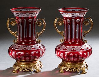 Pair of Brass Ormolu Mounted Ruby Cut-to-Clear Glass Baluster Vases, 20th/21st c., the everted neck over scrolled handles, on a pierced circular leaf 