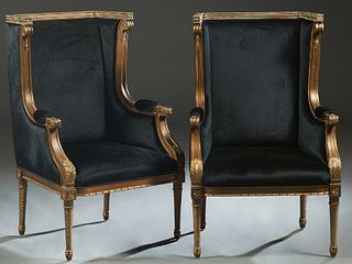 Pair of French Style Carved Giltwood Upholstered Wing Chairs, 20th/21st c., the beaded crest rail over curved upholstered arms, to a bowed seat, on tw