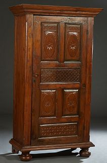 Indonesian Carved Mahogany Armoire, 20th c., the stepped crown over a single door with four floral carved vertical panels and two geometric carved hor