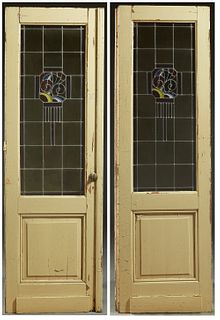 Pair of Art Deco Stained and Leaded Glass Doors, c. 1930, the tops with geometric designs centering pale yellow glass with a brown glass border, H.- 9