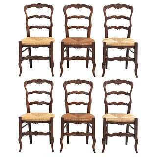 Lote de 6 sillas. Francia. Siglo XX. Estilo Luis XV. En talla de madera de roble. Con respaldos escalonados y asientos de palma tejida.