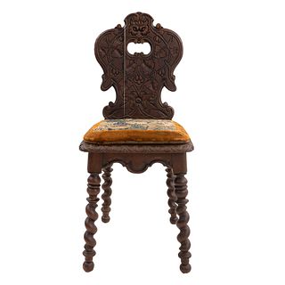 Silla. Francia. Siglo XX. En talla de madera de roble. Conrespaldo semiabierto y asiento acojinado en tapicería color ocre.