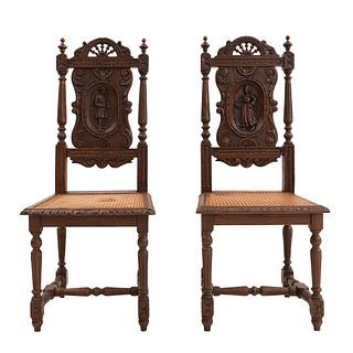Par de sillas. Francia. Siglo XX. Estilo Bretón. En talla de madera de roble. Con respaldos semiabiertos y asientos de bejucos.