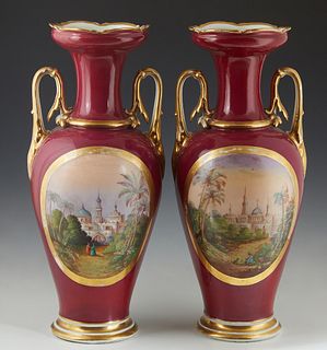 Pair of Continental Baluster Handled Porcelain Vases, 19th c., with gilt decoration and hand-painted reserves of scenes of India, on a magenta ground,