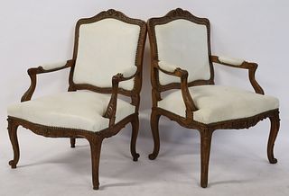 A Pair Of Louis XV Style Carved Arm Chairs .