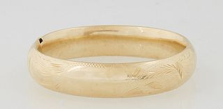 Lady's 18K Victorian Style Hinged Bangle Bracelet, 20th c., with leaf engraving, Int. H.- 2 in., W.- 2 1/4 in., Wt.- .71 Troy Oz. Provenance: The Esta
