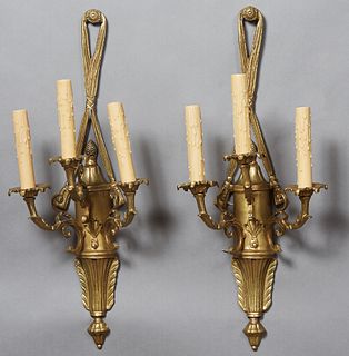 Pair of Louis XVI Style Gilt Bronze Three Light Sconces, 20th c., with a looped "drapery" hanger over a torch form back plate issuing three scrolled r