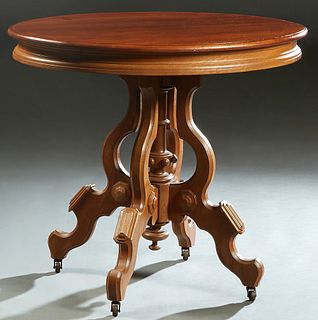 American Carved Walnut Oval Lamp Table, late 19th c., the rounded edge stepped top with one side frieze drawer, on four flat cabriole legs around a tu