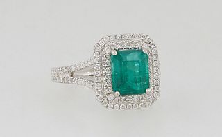 Ladys's Platinum Dinner Ring, with a 2.35 carat emerald atop a double graduated octagonal band of small round diamonds, the split shoulders of the ban