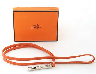 Hermes Ultrasonic Silver Whistle Necklace, with an orange calf leather rope, with Hermes booklet and presentation box, L.- 19 1/2 in.