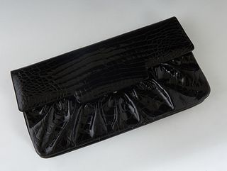 Vintage Judith Leiber Black Patent Leather Faux Alligator Clutch, with gold hardware and a push latch closure, the interior of the bag lined in a blac