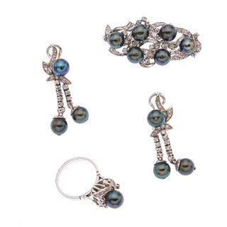 Prendedor, anillo y par de aretes con perlas y diamantes en plata paladio. 13 perlas cultivadas color verde de 5 mm. 76 diamante...