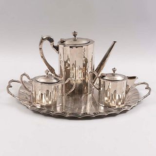 Juego de té. Siglo XX. Elaborado en metal plateado, diseños estriados, charola diseño oval con motivos gallonados. Piezas: 4