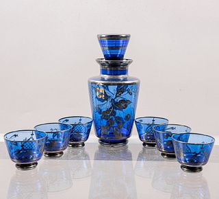 Lote de licorera y 6 shots. Siglo XX. Elaborados en vidrio soplado color azul. Decorados con elementos vegetales y frutales.