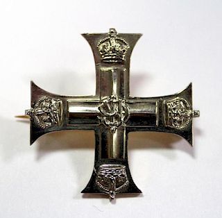 A silver and gold coloured brooch formed as a miniature Military Cross, associated with the Military