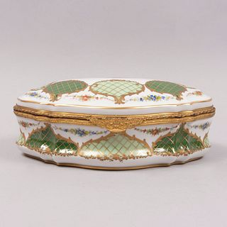 Alhajero. Francia. SXX. En porcelana JD con aplicaciones de metal dorado. Decorado con elementos florales, cestería y esmalte dorado.