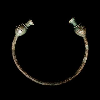 A Celtic Bronze Torc with Poppy-Head Terminals  
Width 7 1/2 inches. 