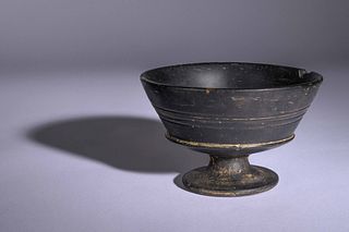 An Etruscan Bucchero Black-Glazed Footed Cup
Height 3 1/4 x diameter 5 1/4 inches. 