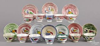Eleven spatter cups and saucers with peafowl de