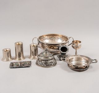 Lote mixto. Diferentes orígenes y diseños. Siglo XX. Elaborados en metal plateado Consta de: 3 candeleros, copa, tintero, otros.