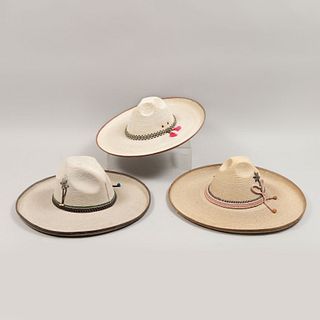 Lote de 3 sombreros de faena. México. Siglo XX. Elaborados en palma tejida. Decorados con toquilla.