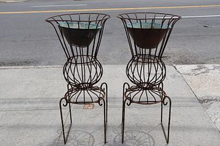 An Antique Pair Of Iron Planters On Stands