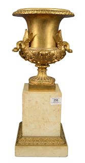 French Empire Dore Bronze Urn, having swan form handles, resting on a marble plinth base, height 19 1/2 inches, depth 9 inches.