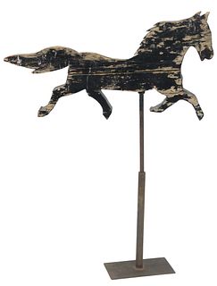 Primitive Wood Horse Weathervane, crudely carved in trotting position and painted black, mounted on an iron stand, length 40 inches.