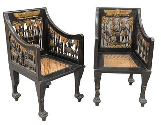 Pair of Egyptian Revival Ebonized Armchairs, having pierced carved backs, arm supports, and caned seats on paw feet, height 37 inches, width 23 inches