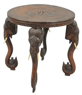 Hardwood Table, having carved top on elephant carved legs, height 25 inches, diameter 24 inches.