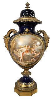 Large Sevres Covered Urn With Cover, having painted scene with puttis and gilt bronze Bacchus handles, overall height 24 inches.
