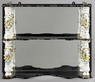 Ebonized hanging shelf, late 19th c., with a mirrored back and porcelain columns, probably Dresden