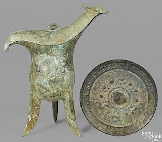 Chinese bronze mirror, 6'' dia., together with an archaic tripod wine vessel or Jue, 10'' h.