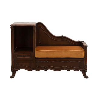 Mueble para teléfono. Italia. SXX. Talla en madera. Con vano, cajón, asiento acojinado y soportes semicurvos. 75 x 110 x 40 cm
