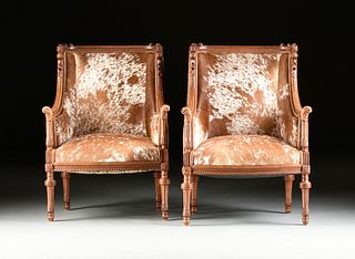 A PAIR OF LOUIS XVI REVIVAL COWHIDE UPHOLSTERED WALNUT BERGÃˆRES Ã€ LA OREILLES, POSSIBLY ENGLISH, LATE 19TH/EARLY 20TH CENTURY,
