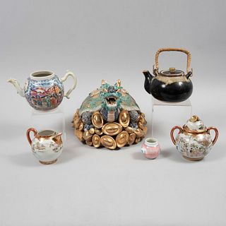 Lote mixto de 6 piezas. Origen oriental. SXX. Elaborados en cerámica y porcelana. Consta de: tortuga, 3 teteras y 2 azucareras.