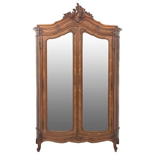 Armario. Francia. Siglo XX. Estilo Luis XV. En talla de madera de nogal. Con puertas abatibles con espejo y soportes tipo cabriolé.