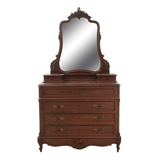 Tocador con espejo. Siglo XX. Estilo Luis XV. En talla de madera de nogal. Con espejo irregular biselado, cubierta de mármol.