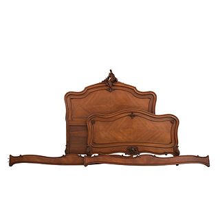 Cama matrimonial. Francia. SXX. Estilo Luis XV. En talla de madera de nogal. Con cabecera, piecera, largueros y soportes tipo cabriolé.
