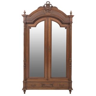 Armario. Francia. Siglo XX. Estilo Enrique II. En talla de madera de roble. Con puertass abatibles, con espejos de lunas irregulares.