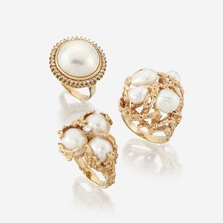 A collection of three pearl and fourteen karat diamond rings