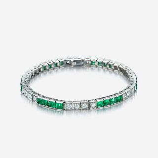 An eighteen karat white gold, diamond, and green stone line bracelet