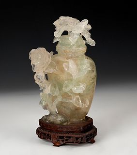 Potiche with flowers. China, 20th century.
Hand-carved translucent jade on a wooden base.