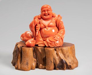 Smiling Buddha. China, 20th century.
Coral.
Wooden base.