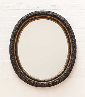 A carved giltwood and ebonised oval wall mirror,