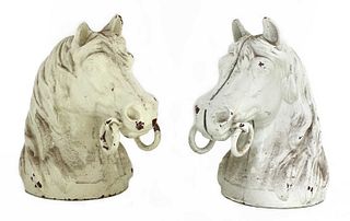 A pair of cast iron horse's head stable brackets,