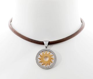 BVLGARI.
Tondo Sun pendant.
In 18kt yellow gold and stainless steel. Brown leather cord with carabiner clasp.