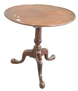 George II Mahogany Tip and Turn Tea Table, on urn shaft and tripod base, 18th century, height 28 1/4 inches, diameter 29 1/2 inches.