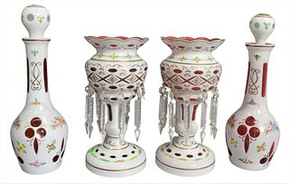 Two Pairs of Cranberry Glass, having white overlay and painted foliate decoration, to include a pair of decanters and a pair of lusters with 10 prisms